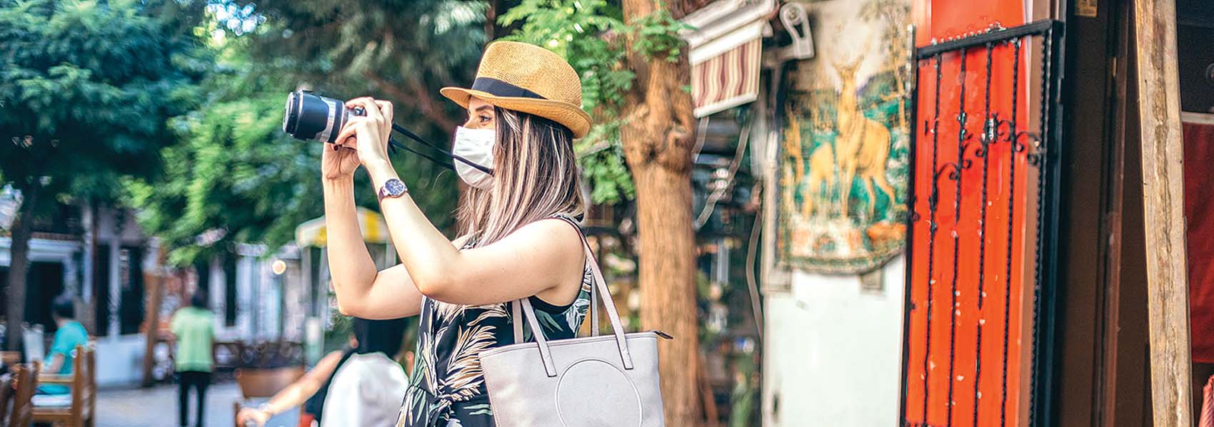 a masked tourist snaps photos in Italy